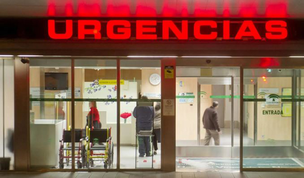 entrada a un servicio de Urgencias hospitalario, identificable por el letrero rojo luminoso.